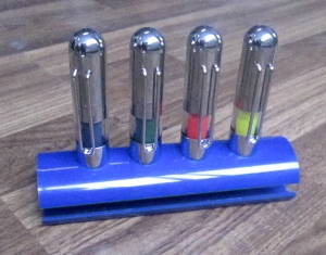 ปากกาไฮไลท์ 4 ด้ามวางบนฐานสีฟ้า