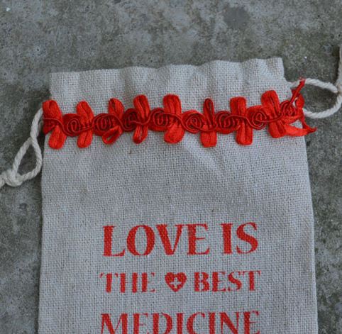 ถุงผ้ากระสอบ ถุงผ้าดิบ สำเร็จรูป พิมพ์ลาย ความหมาย รักคือยาที่ดีที่สุด แต่งโบว์สีแดง ถุงผ้าขนาด 10x15 cm 711461